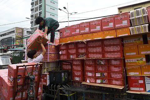 Workers unload boxes of fruits from a delivery vehicle at a commercial area in Manila. The International Trade Union Confederation listed the Philippines among the 10 worst countries for workers in 2025, alongside Bangladesh, Belarus, Ecuador, Egypt, Eswatini, Myanmar, Nigeria, Tunisia and Turkiye due to systemic violations of workers’ rights.