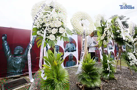 Caretakers arrange flowers offered by Quezon City officials at the Cry of Pugad Lawin Shrine on Saturday, August 23, 2025, during the 129th anniversary of the historic uprising that declared independence from Spanish colonial rule.