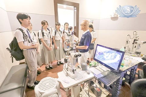 STUDENTS from University’s College of Medicine in Taiwan listen to a Tzu Chi Eye Center volunteer touring them at the hospital.