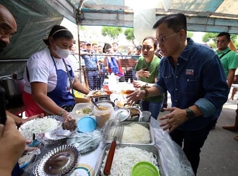 SENATOR Bong Go buys food from a local vendor during one of his community visits to show support for small entrepreneurs.