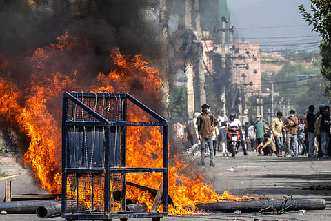 A police barricade is pictured in front of a fire set alight by demonstrators during a protest outside the Parliament in Kathmandu on September 8, 2025, against social media prohibitions and corruption by the government. Nepal police on September 8 opened fire, killing at least 17 people as thousands of young protesters took to the streets of Kathmandu demanding the government lift a social media ban and tackle corruption.
