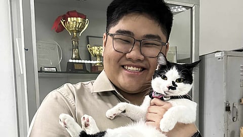 Benilde Industrial Design graduate Enrico Miguel Velasquez with his cat Pepper.
