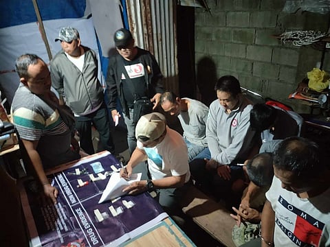 SHABU SNARE | Bataan PNP operatives document seized shabu worth ₱57,256 during a September 11, 2025 anti-drug operation in Barangay Luacan, Dinalupihan. Five suspects (background) were arrested for alleged drug peddling and possession.| Franco Regala