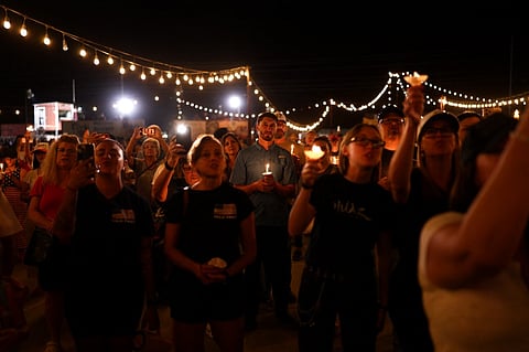People hold candles during a vigil in memory of right-wing activist Charlie Kirk in Morristown, Arizona, on September 13, 2025. The 31-year-old Kirk was hit by a single bullet while addressing a large crowd at Utah Valley University in the town of Orem on September 10.
