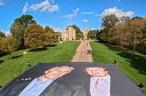 Activists unfurling a large photo depicting US President Donald Trump posing with Jeffrey Epstein, on the Long Walk, outside Windsor Castle in Windsor, on 15 September 2025, ahead of a State visit by the US president. 