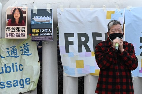 Democracy activist Lee Cheuk-Yan speaks outside China's Liaison Office in Hong Kong on December 28, 2020, during a protest calling on China to free a group of Hong Kong democracy activists facing trial in China, after they attempted to flee the territory by speedboat to Taiwan last August, as well as Chinese citizen journalist Zhang Zhan (top L poster) who was jailed for four years for her livestream reporting from Wuhan as the Covid-19 outbreak unfurled.


