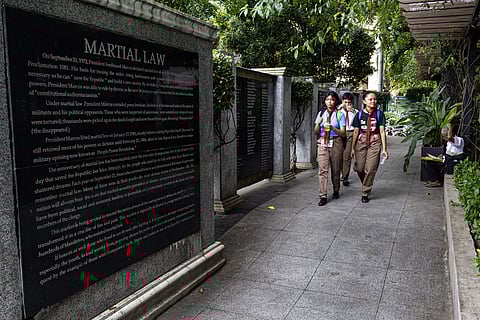 Students walk past the Victims of Martial Law Memorial Wall in Manila on Saturday, 20 September 2025, a day before the late dictator Ferdinand Marcos Sr. signed Proclamation No. 1081, marking the beginning of a fourteen-year period of Martial Law.