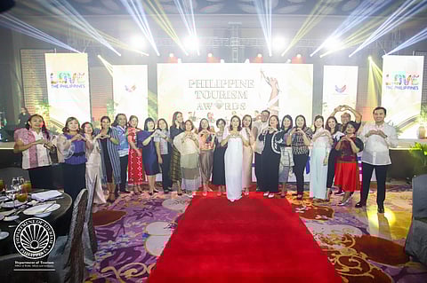 Tourism Secretary Christina Garcia Frasco shares a heart sign with winners of the Philippine Tourism Awards.
