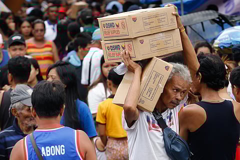 Residents of Happyland in Tondo, Manila, queue for Department of Social Welfare and Development family food packs on Saturday morning. The community was struck by a fire on September 13 that escalated to Task Force Bravo.