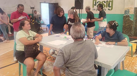 NHA staff assisting beneficiaries in Brgy. Manggahan, Pasig City, on 25 September, giving out P1,840,000 to 65 beneficiaries whose houses were damaged due to a fire. 