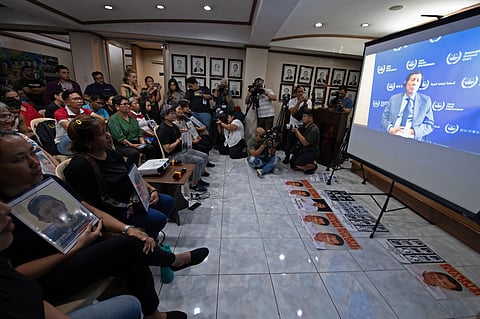 Silent witnesses Families of Duterte’s drug war victims clutch portraits as they watch the former president’s first ICC hearing streamed in a Manila church in March. 