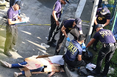 Scene of the Crime Operatives (QCPD-SOCO) examine the body of a man allegedly gunned down by motorcycle-riding assailants along Katipunan Avenue, Barangay Loyola Heights, Quezon City.