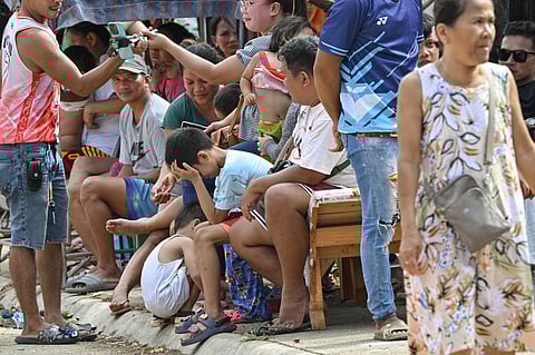 People gather at a temporary shelter outside their homes inside a housing project for survivors of Super Typhoon Haiyan in Bogo City, Cebu province on October 2, 2025, in the aftermath of a 6.9-magnitude quake that struck off the coast of the central Philippines late September 30. The death toll from a powerful earthquake in the central Philippines rose to 72 on October 2, rescuers said, as officials turned their efforts to the hundreds injured and thousands left homeless.