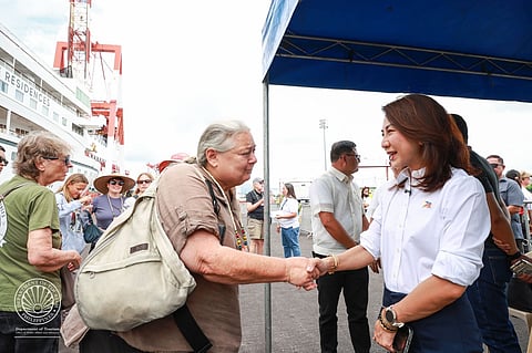 Tourism Secretary Christina Garcia Frasco welcomes international tourists onboard the Villa Vie Odyssey cruise vessel after docking in Cebu International Port for its call on Sunday.
