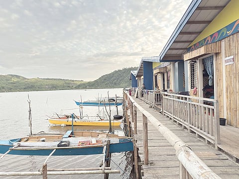 
UN-HABITAT, through funding from the Spanish government, resettled badjao families displaced by super typhoon ‘Odette’ in Surigao in December 2021, to modern quadruplex homes with concrete stilts, water, electricity and ecological septic tank. (Inset) The beneficiaries formerly live in wooden stilt houses outside a cove.