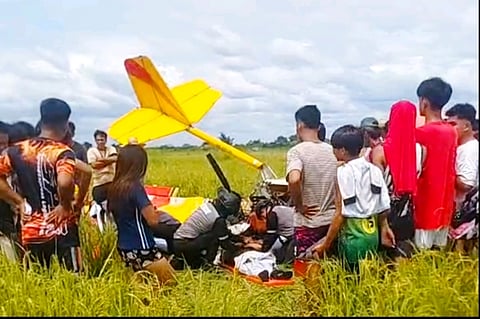 TRAGIC AFTERMATH | Scene from Barangay Panalicsican, Concepcion, Tarlac, following the ultralight aircraft crash. Residents gather as authorities investigate the fatal incident. The Tarlac PPO urges witnesses to come forward with information.