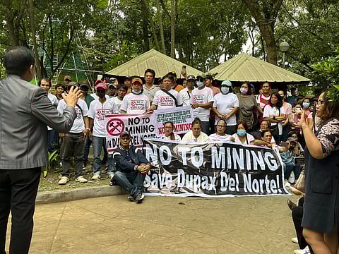 Anti-mining villagers of Dupax del Norte hold signs to assert their resistance against mining operations. The demonstration persists despite an RTC ruling that extended a TRO, legally prohibiting residents from blocking the entry of mine workers and equipment.