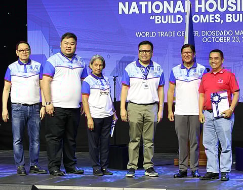 Joining President Ferdinand R. Marcos Jr. (second from right) in the ceremonial awarding of Certificates of Lot Award to beneficiaries of the Social Housing Finance Corporation’s Enhanced Community Mortgage Program during the National Housing Expo at the World Trade Center in Pasay City on Thursday, 23 October are Department of Human Settlements and Urban Development Secretary Jose Ramon Aliling (third from right), SHFC president and CEO Federico Laxa (left), NHA general manager Joeben Tai and Pag-IBIG Fund CEO Marilene Acosta.