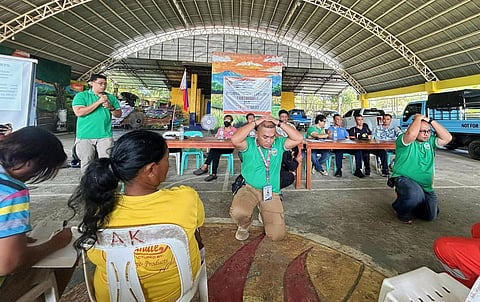 Participants duck, cover, and hold during the regionwide earthquake and tsunami drill in Banate, Iloilo, on Oct. 23, 2025, organized by the Provincial Disaster Risk Reduction and Management Office (PDRRMO) together with the Banate MDRRMO and barangay officials.