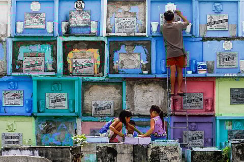Informal settlers earn additional income during the observance of Undas by cleaning and repainting tombs and grave markers at the Manila North Cemetery.