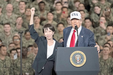 Japan’S Prime Minister Sanae Takaichi (left) gestures as US President Donald Trump delivers a speech in front of US Navy personnel on board the US Navy’s USS George Washington aircraft carrier at the US naval base in Yokosuka on 28 October 2025.