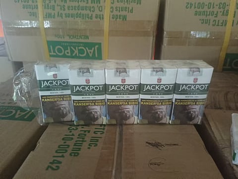 Boxes of suspected counterfeit cigarettes are found inside a facility raided by police and labor officials in Trece Martires City, Cavite, on Friday. Authorities said the operation resulted in the arrest of two men and the rescue of 11 workers.