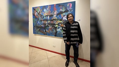 Jonathan Olazo with one of his artworks on display.