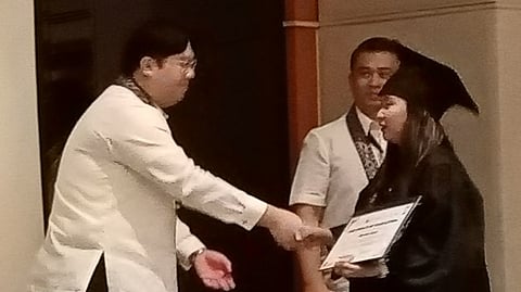 
ONE of the graduates of the caregiver scholarship is congratulated by Martin Joel Barrameda II, project officer of Bloomberry Cultural Foundation Inc. 