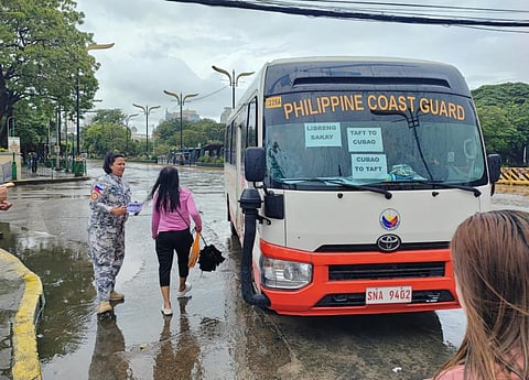 A personnel of the Philippine Coast Guard assist a passenger during a Libreng Sakay effort on Monday in Quezon City.