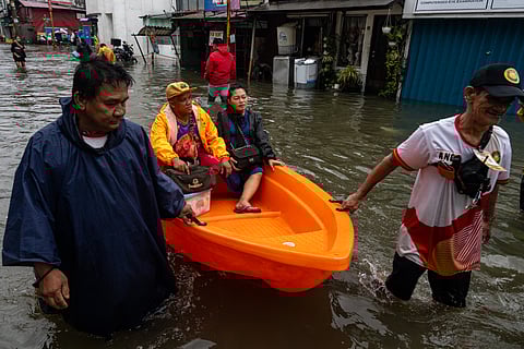 People wade through chest-deep floodwater in Barangay Navotas East, Navotas City on Monday, 10 November 2025, after the Malabon-Navotas Navigational Gate overflowed Sunday night amid high tide and storm surges driven by Super Typhoon Uwan.