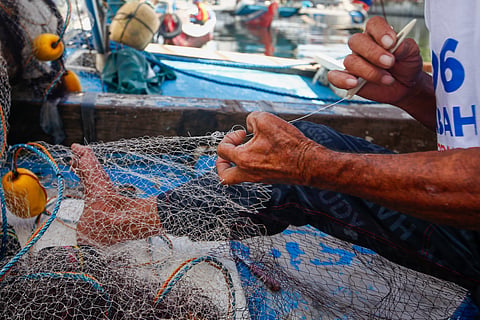 Fishermen repair their nets along the Tullahan River in Navotas City on World Fisheries Day, 21 November 2025. Despite being vital to the country’s food security, small-scale fishers remain among the most economically marginalized and highly vulnerable to climate impacts.
