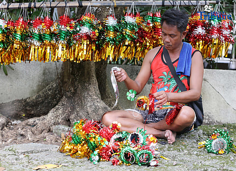 A man sells a Christmas lantern he made himself along NIA Road in Quezon City on 21 November 2025, 34 days before Christmas.