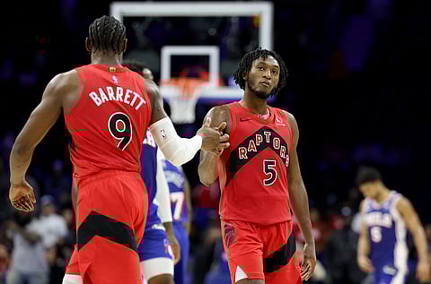 Immanuel Quickley #5 of the Toronto Raptors celebrates with RJ Barrett #9 during the second half against the Philadelphia 76ers at Xfinity Mobile Arena on November 19, 2025 in Philadelphia, Pennsylvania. E