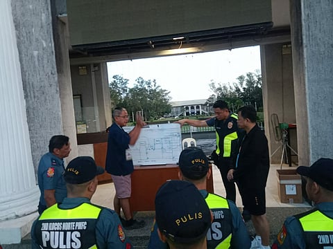 Police officers and security personnel receive a detailed pre-operation briefing at the MMSU campus as authorities tighten security amid a series of bomb threats that disrupted classes and triggered multiple evacuations throughout November 2025. Investigators say digital leads and interagency coordination are steadily closing in on the source of the threats.