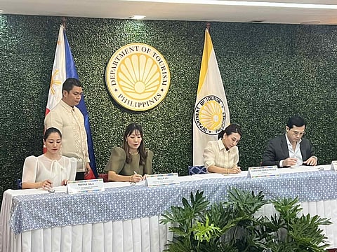 Tourism Secretary Christina Garcia Frasco (seated, 3rd from left) and Visa regional head for Southeast Asia, Visa Government Solutions Bella Lai (seated, 2nd from left), sign the memorandum of understanding in a bid to drive digital payment acceptance in key tourist destinations, support micro, small, and medium enterprises, and advance data-driven tourism planning. 
