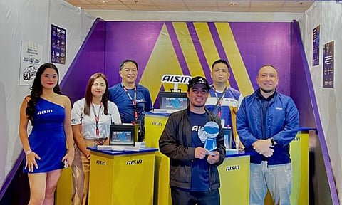 TEAM members from Aisin pose at the booth during the soft preview of the upcoming Aisin Battery.