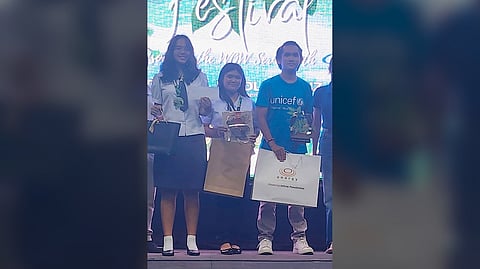 NATIONAL Wildlife Quiz Bowl champion, Grace D. Tuante and Janella B. Vera, with their coach Silvestre M. Solomon Ill, from Himamaylan National High School.