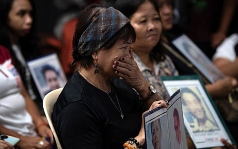 Families of Duterte’s drug war victims watch his first ICC appearance since his 11 March arrest during a live stream at a Manila church on 14 March 2025.