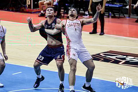 JOMEL Puno of San Beda (right) and Mark Omega of Letran brace for a tough Game 2 in the Season 101 NCAA basketball tournament best-of-three title series.