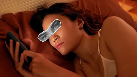 A girl stretched out on her bed, lost in the glow of her phone.