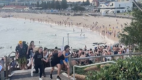 Beach goers hurriedly leaving Bondi Beach during the mass shooting by two gunmen. 