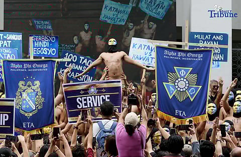 Members of the Alpha Phi Omega Philippines (APO) fraternity stage a protest run at the University of the Philippines Diliman in Quezon City on Wednesday, December 17, 2025, during the organization’s centennial celebration. Participants carried placards criticizing alleged flood control projects as part of their demonstration.