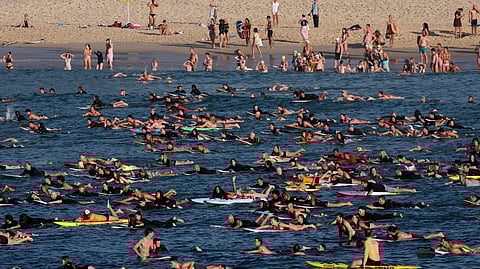 SURFERS and swimmers paddle and swim together at Bondi Beach as they participate in a tribute to the victims of the 14 December Bondi Beach shooting attack, in Sydney on 19 December 2025.