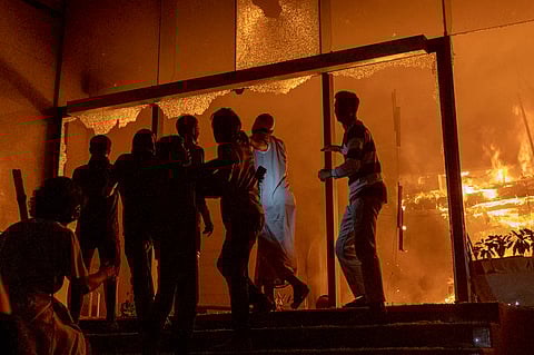 PEOPLE are seen at the entrance to the Daily Star building as it burns in Dhaka on 19 December 2025, amid protests following the news of the death of youth leader Sharif Osman Hadi. 