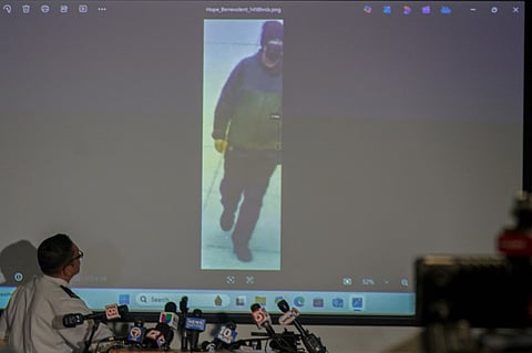 Colonel Oscar Perez (L), chief of the Providence Police Department, projects an image of a "person of interest" in the December 13 mass shooting at Brown University during a press conference at the Providence Public Safety Complex in Providence, Rhode Island, on December 15, 2025. A gunman remained at large after a weekend mass shooting at elite Brown University left two dead and nine wounded, with US authorities releasing new footage of a masked "person of interest" captured on surveillance cameras. The shooting took place Saturday in a building where exams were underway on the Ivy League campus in Providence, Rhode Island when a man with a rifle burst in and opened fire before fleeing.
