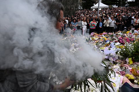 Mourners take part in a smoking ceremony and candlelight vigil at Bondi Pavilion in Sydney on December 16, 2025, honoring the victims of the Bondi Beach shooting. Australia's leaders have agreed to toughen gun laws after attackers killed 15 people at a Jewish festival on Bondi Beach, the worst mass shooting in decades decried as antisemitic "terrorism" by authorities.
