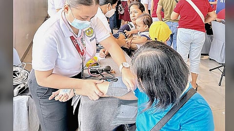 VOLUNTEERS measure beneficiaries’ blood pressure and assist them in proceeding to the next steps of their medical examination.