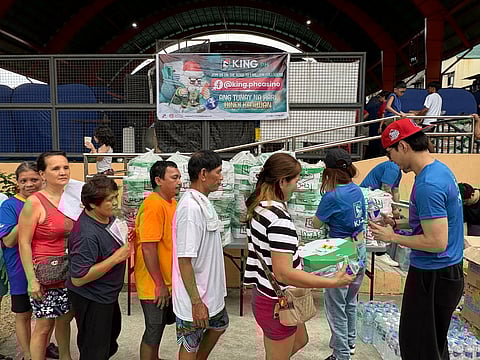 RESIDENTS of Barangay Pleasant Hills, Mandaluyong line up for the food, water and King.PH merchandise from King.PH in their corporate social responsibility (CSR) outreach in Purok Tres Covered Court in Mandaluyong City 