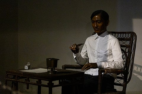 A wooden sculpture of national hero Jose Rizal depicts him writing.