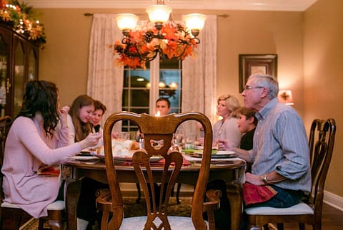 A FAMILY having dinner with an empty seat. 